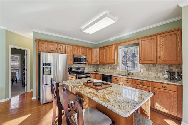 kitchen with a kitchen island, decorative backsplash, sink, light stone countertops, and stainless steel appliances