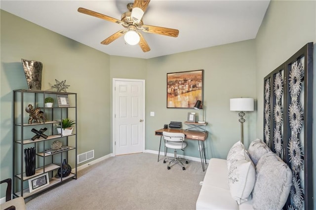 carpeted office space featuring ceiling fan