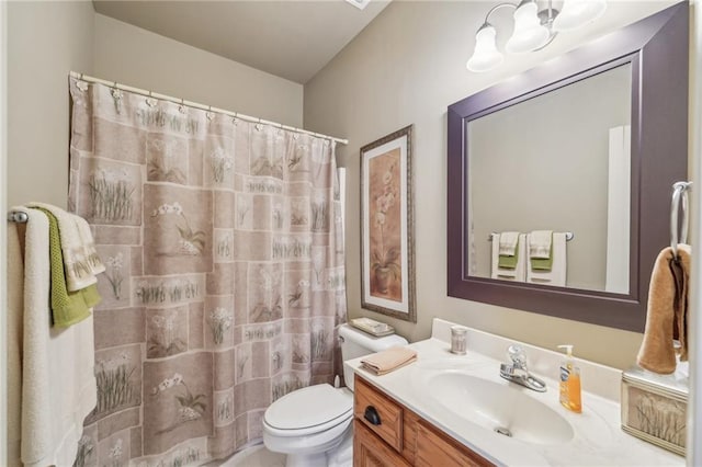 bathroom featuring toilet, vanity, and a shower with curtain