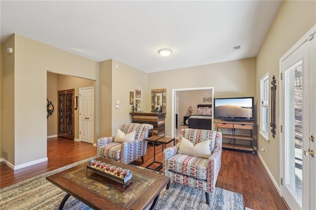 living room with dark wood-type flooring and plenty of natural light