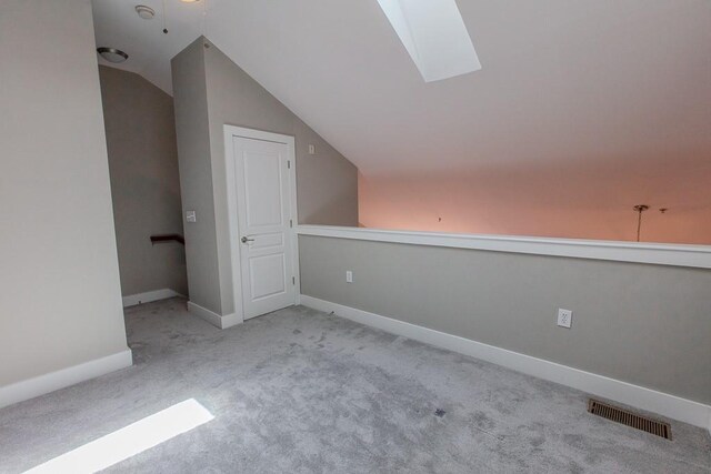 799 Hammond Dr Unit 406, Atlanta, GA 30328 - additional living space featuring vaulted ceiling with skylight, baseboards, visible vents, and carpet floors