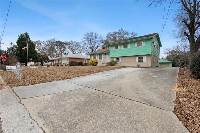 tri-level home featuring a detached garage and driveway