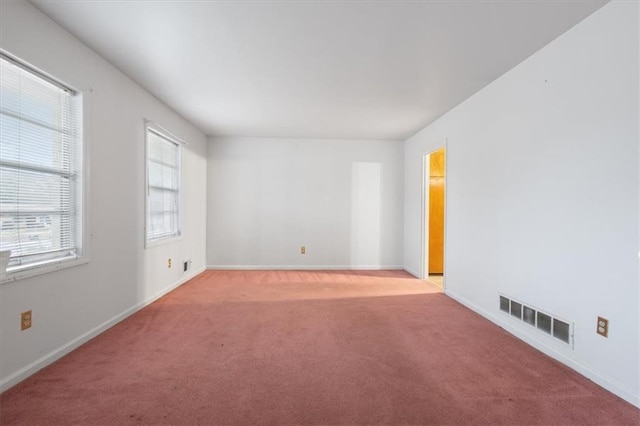 spare room featuring visible vents, carpet, and baseboards