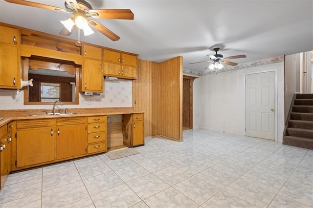 kitchen with a sink, light countertops, ceiling fan, and brown cabinets