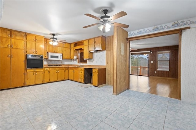 kitchen featuring wallpapered walls, ceiling fan, white microwave, and oven