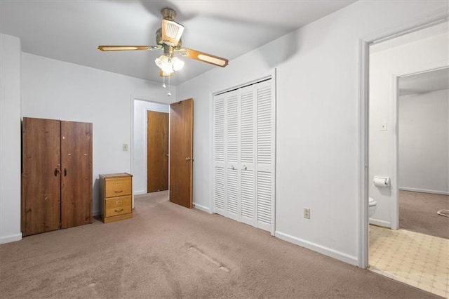 unfurnished bedroom with baseboards, ensuite bath, carpet, and a closet