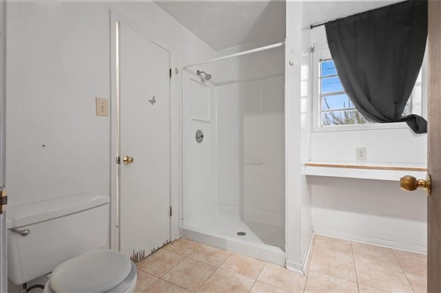 full bath featuring tile patterned floors, a textured ceiling, a stall shower, and toilet