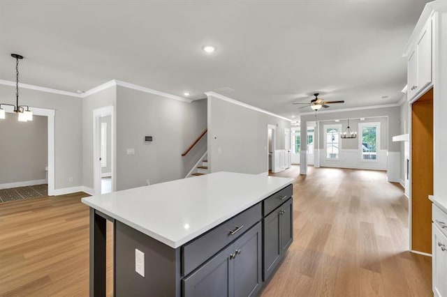 231 E Marable St, Monroe, GA 30655 - kitchen with a ceiling fan, light wood-style floors, ornamental molding, light countertops, and a center island