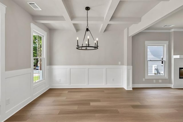 231 E Marable St, Monroe, GA 30655 - unfurnished dining area featuring a chandelier, coffered ceiling, beamed ceiling, light wood-type flooring, and wainscoting