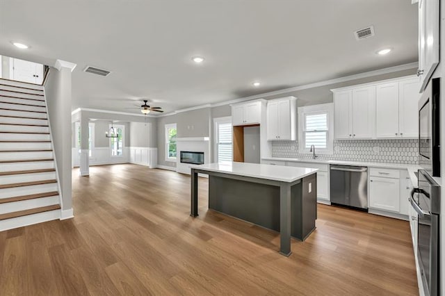 231 E Marable St, Monroe, GA 30655 - kitchen with appliances with stainless steel finishes, a sink, ceiling fan, crown molding, and decorative backsplash