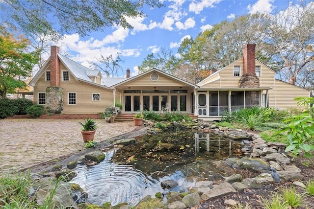 rear view of property featuring a sunroom