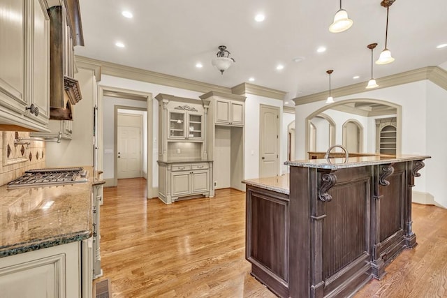 9145 Greenway Ct, Gainesville, GA 30506 - kitchen featuring cream cabinets, ornamental molding, light wood finished floors, decorative backsplash, and a kitchen breakfast bar