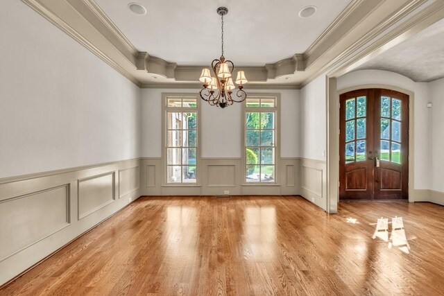 9145 Greenway Ct, Gainesville, GA 30506 - unfurnished dining area with french doors, crown molding, a chandelier, wood finished floors, and a wainscoted wall