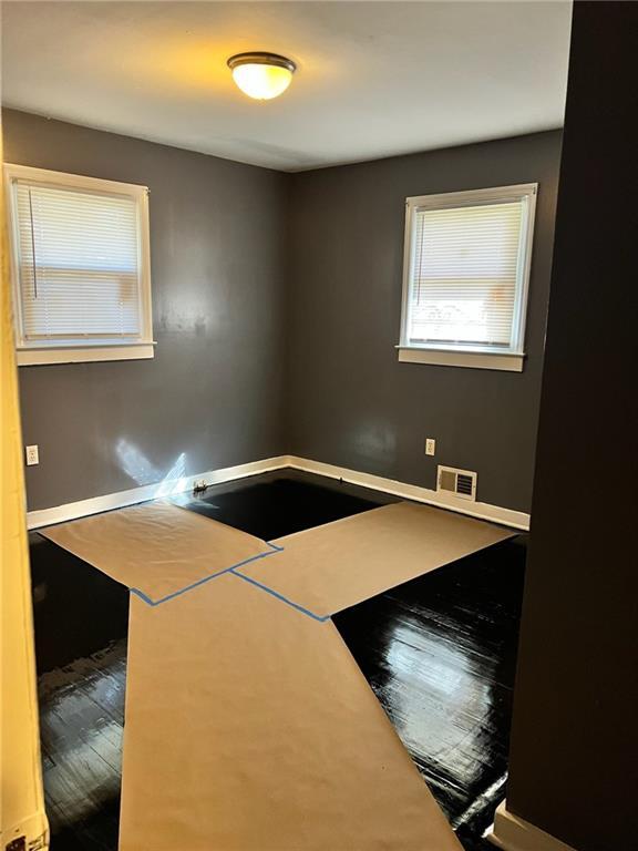 spare room featuring wood-type flooring