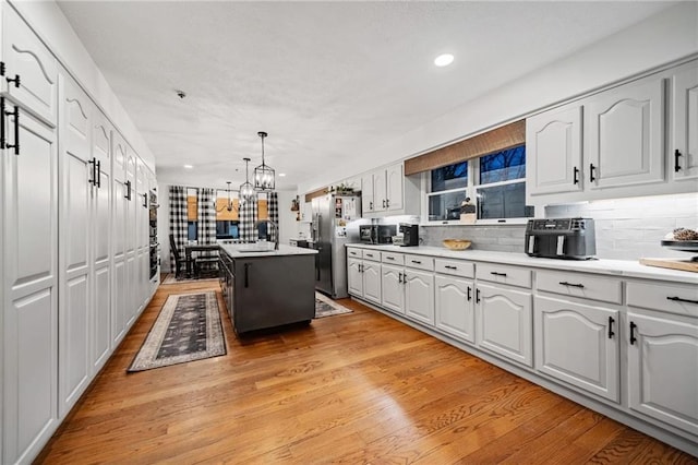 kitchen featuring light countertops, white cabinets, and a center island