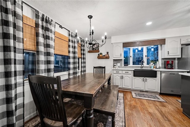 dining room featuring light wood-style floors, recessed lighting, a chandelier, and a textured ceiling