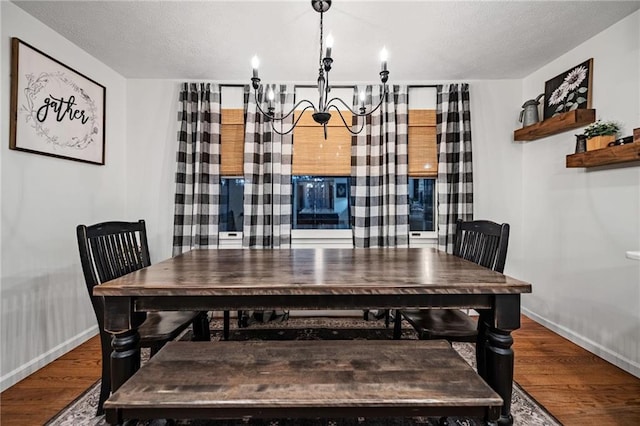 dining area featuring a notable chandelier, baseboards, and wood finished floors