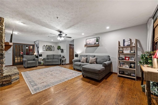 living room featuring recessed lighting, ceiling fan, a textured ceiling, and wood finished floors