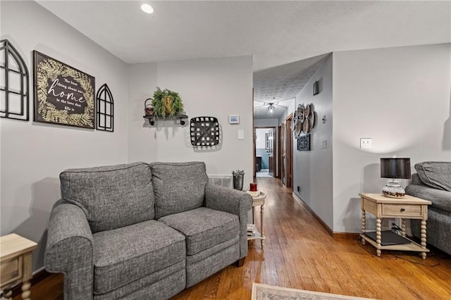 living area with visible vents, baseboards, and wood finished floors