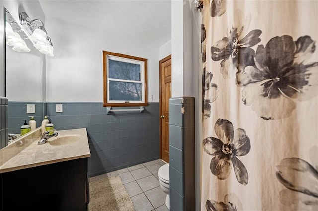 bathroom featuring tile patterned flooring, toilet, a wainscoted wall, a shower with shower curtain, and vanity