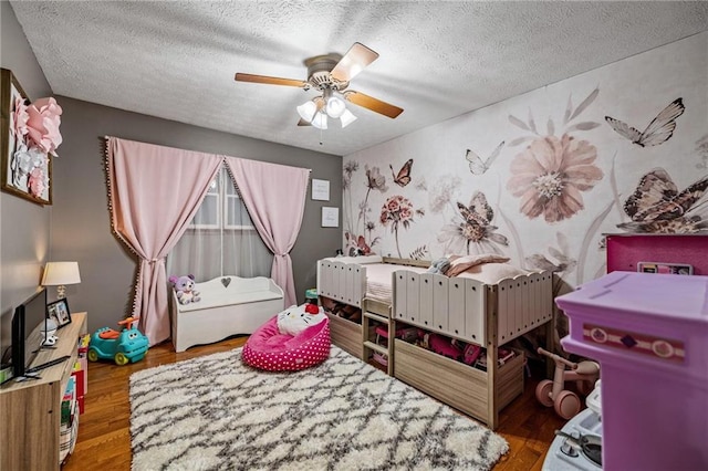 bedroom with a textured ceiling, a ceiling fan, and wood finished floors