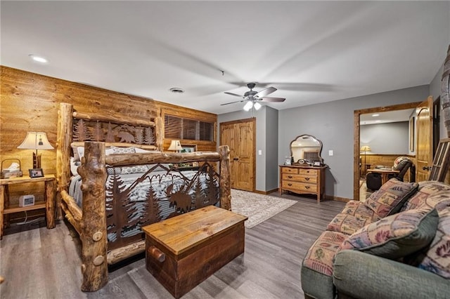 bedroom with dark wood-type flooring, a ceiling fan, visible vents, and baseboards