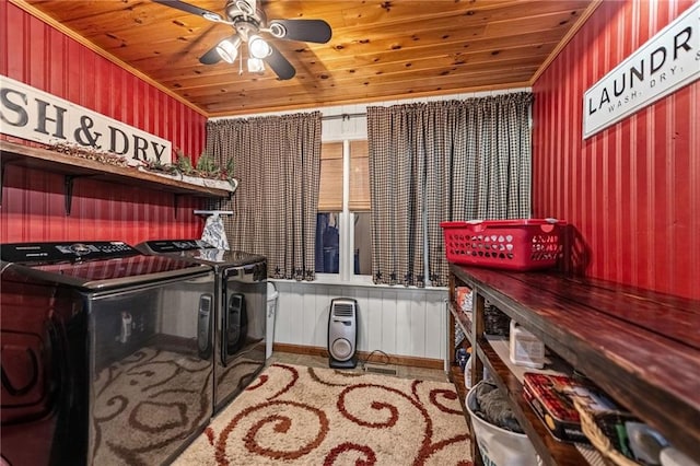 clothes washing area featuring laundry area, wood ceiling, a ceiling fan, and washer and dryer