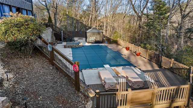 view of swimming pool featuring a storage shed, an outbuilding, fence, and a fenced in pool