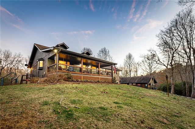 rear view of property featuring a lawn