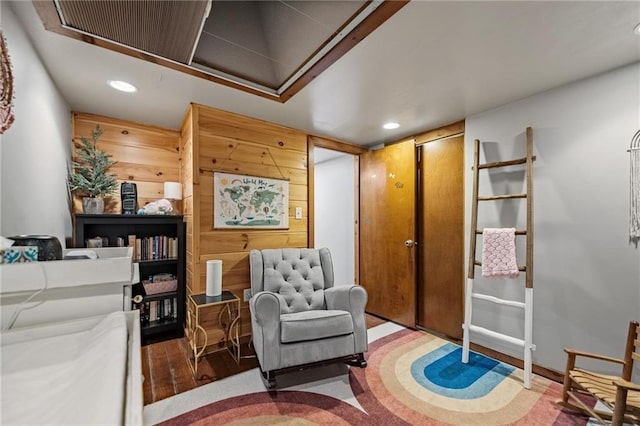 sitting room featuring recessed lighting, wooden walls, and wood finished floors