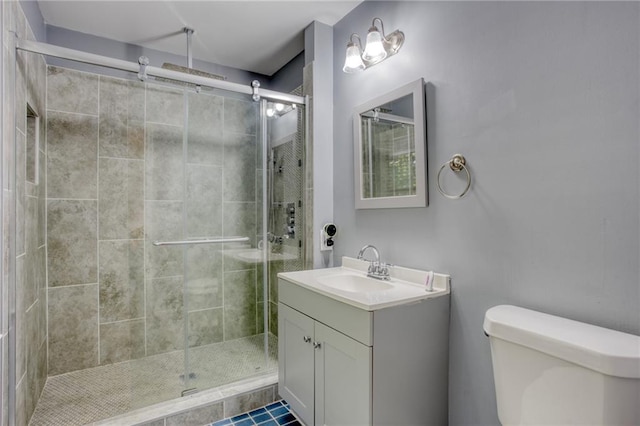 bathroom featuring tile patterned floors, vanity, an enclosed shower, and toilet