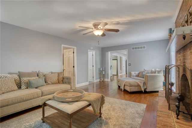 living room with a fireplace, hardwood / wood-style floors, and ceiling fan