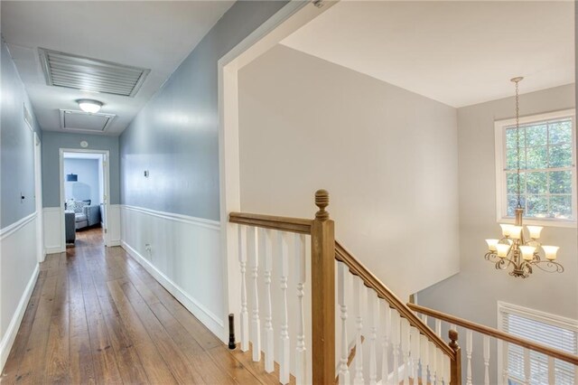 hallway with a notable chandelier and hardwood / wood-style flooring