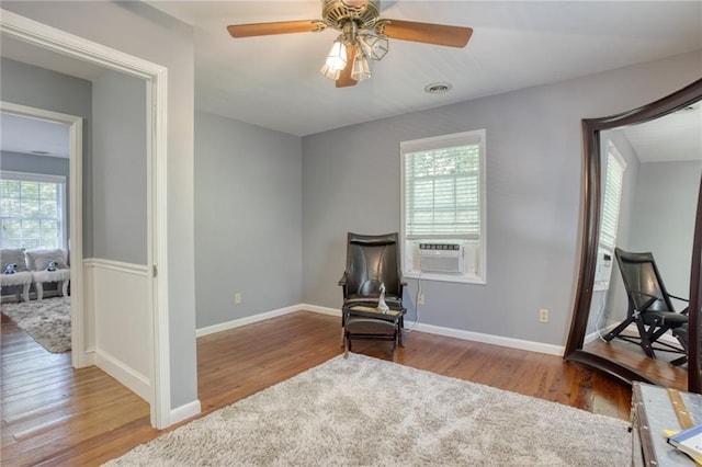 sitting room featuring hardwood / wood-style floors, ceiling fan, and a healthy amount of sunlight