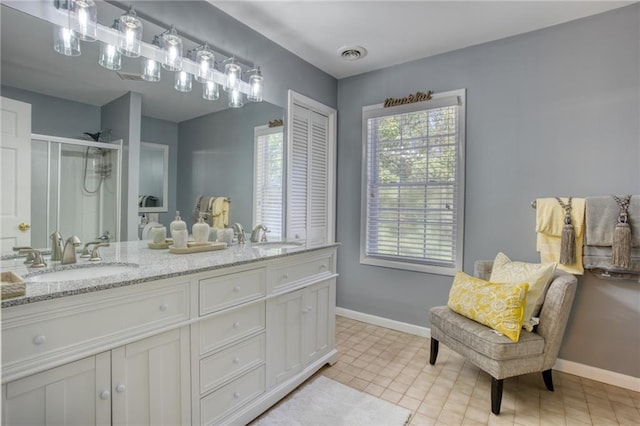 bathroom with tile patterned flooring, vanity, and a shower with door