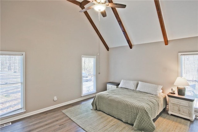 bedroom with wood finished floors, baseboards, visible vents, high vaulted ceiling, and beamed ceiling