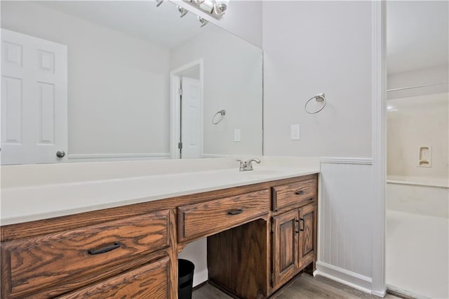 bathroom featuring vanity, wood finished floors, and a wainscoted wall