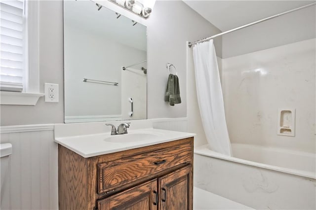 bathroom with vanity, shower / tub combo with curtain, and wainscoting