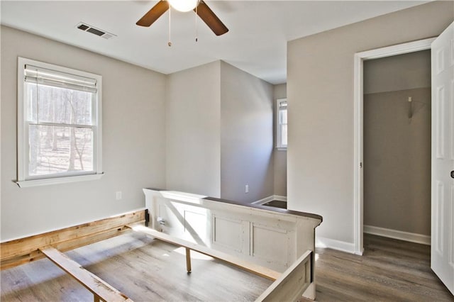 bedroom featuring dark wood-style floors, visible vents, a ceiling fan, and baseboards