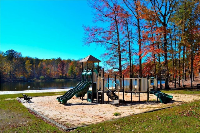 community jungle gym featuring a wooded view and a water view