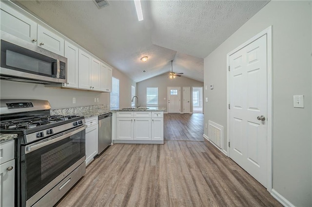 kitchen featuring sink, white cabinetry, stainless steel appliances, kitchen peninsula, and light wood-type flooring