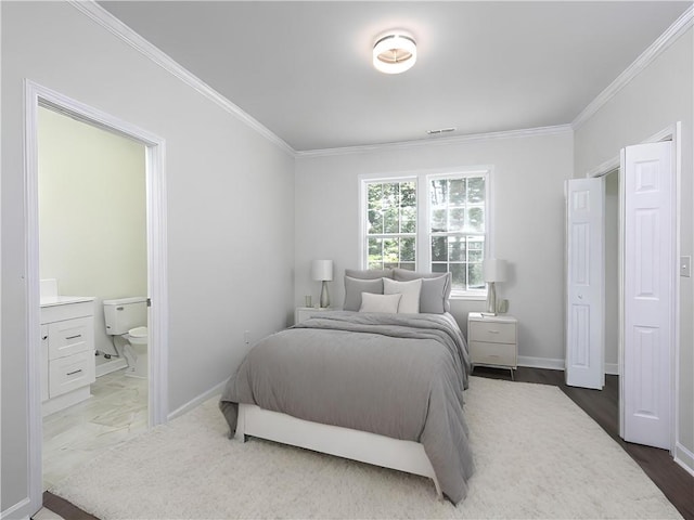 bedroom with ensuite bathroom, dark hardwood / wood-style floors, and ornamental molding