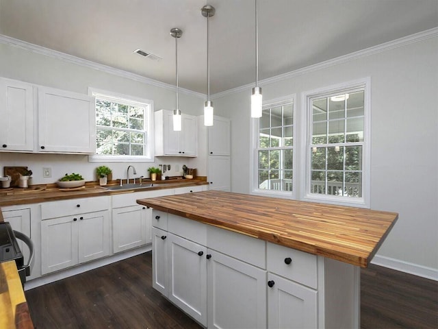 kitchen featuring pendant lighting, dark hardwood / wood-style flooring, white cabinetry, and wooden counters