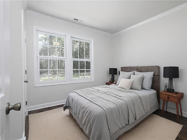 bedroom featuring ornamental molding and hardwood / wood-style flooring