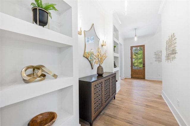 hallway with built in features and light wood-type flooring