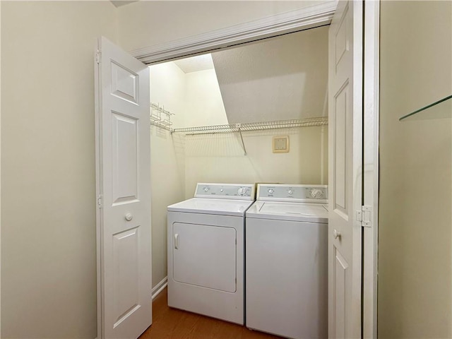 clothes washing area featuring light wood finished floors, laundry area, and separate washer and dryer