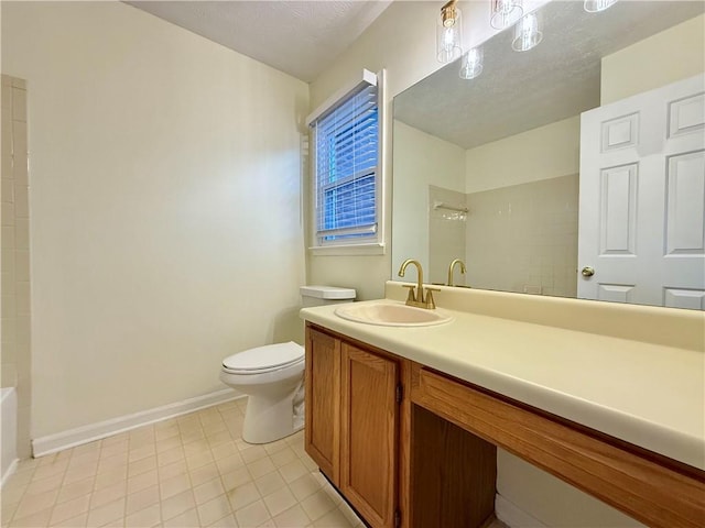 bathroom featuring baseboards, vanity, toilet, and a textured ceiling