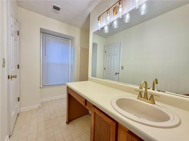 bathroom featuring tile patterned flooring, visible vents, vanity, and baseboards