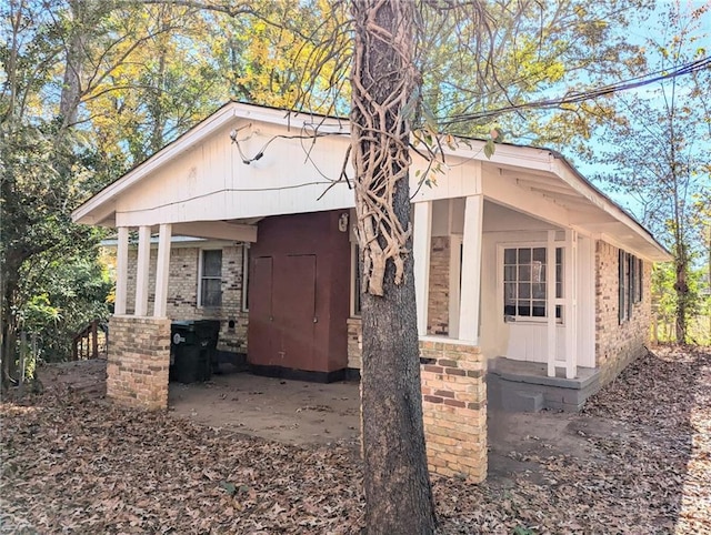 view of home's exterior featuring covered porch and brick siding