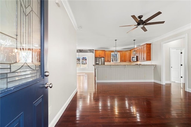 unfurnished living room with crown molding, ceiling fan, and dark hardwood / wood-style floors